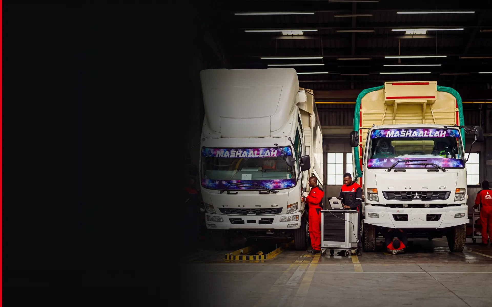 FUSO technicians running diagnostics on two trucks in a service bay