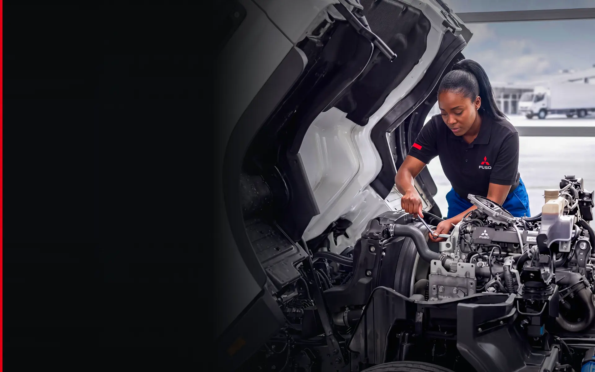 FUSO technician servicing a truck engine with the cab tilted